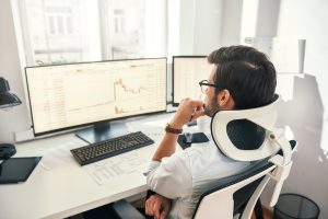 Analyst reviewing financial charts on a desktop monitor