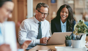 two people looking at a laptop