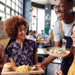 a group of people being served food in a restaurant