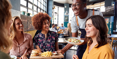 a group of people being served food in a restaurant