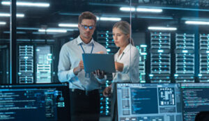 two people looking at a computer in a server room